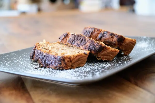 Three slices of banana bread dusted with icing sugar