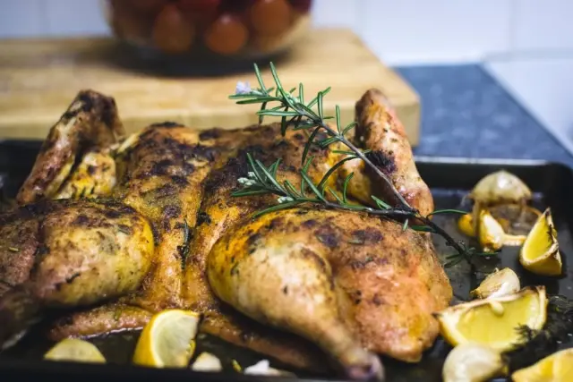 Roast lemon chicken with rosemary on a dark tray